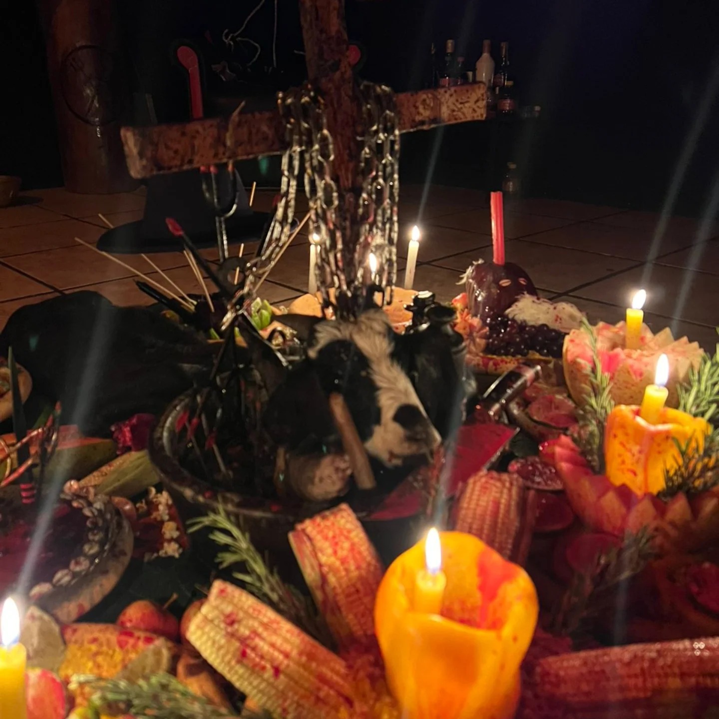 Assentamento ritualístico com cruz, correntes e oferendas